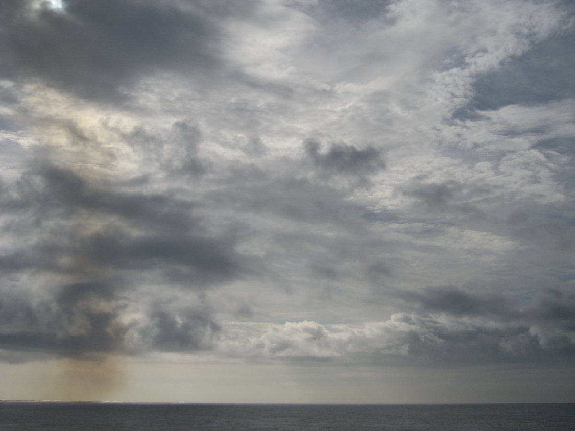 auf eine merkwürdige Verfärbung des Himmels. Die MS CRÈME BRULÉE mit ihren 27 Schornsteinen? Einer der Gold-Krater im Tonga-Tiefseegraben? Oder doch nur der schmutzige Fuß eines Regenbogens? (180)