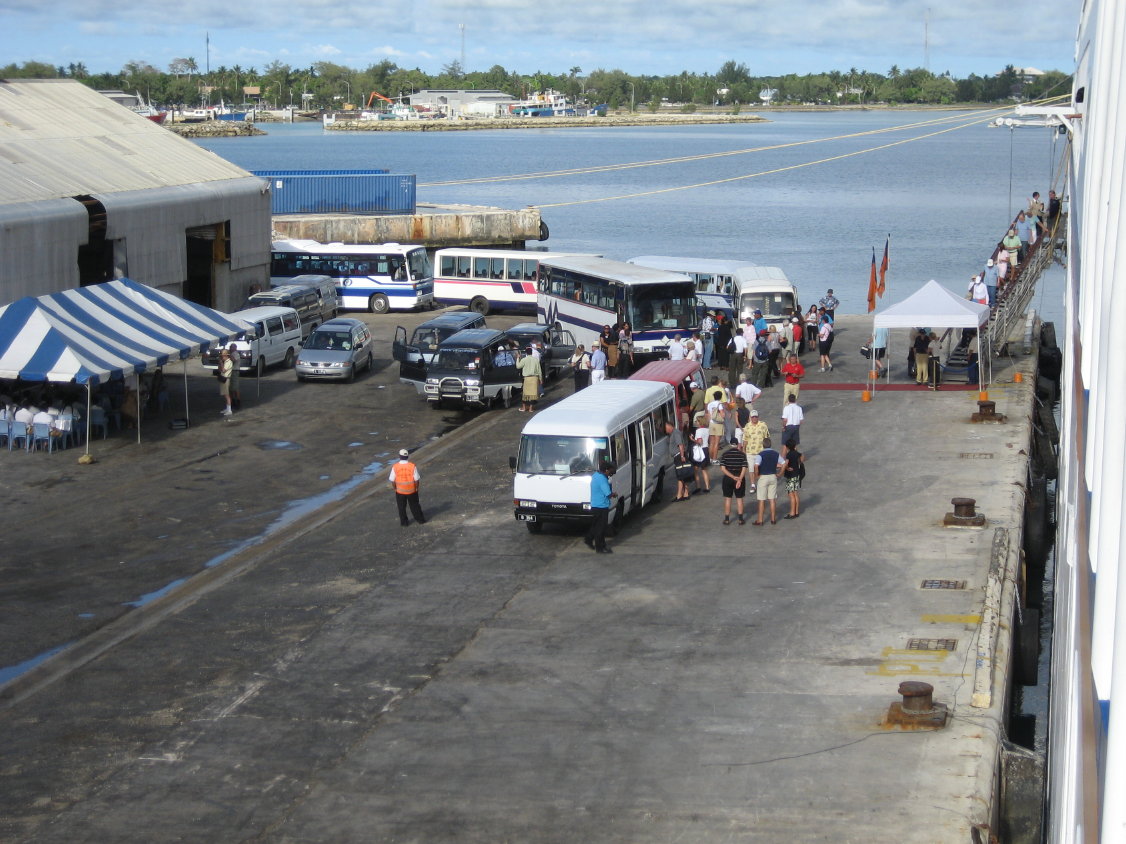 auf den Queen-Salote-Kai von Nukualofa: Einmarsch der Gäste im Königreich Tonga. Unterm blauweiß gestreifen Zeltdach spielt dazu die Blasmusik. (180)